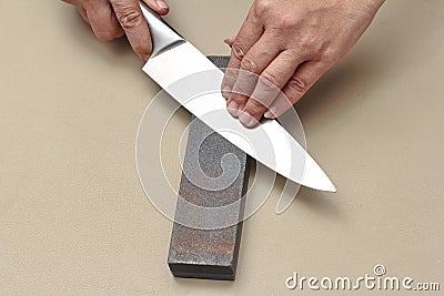 Handle the knife to make a sharp knife with a whetstone. Stock Photo