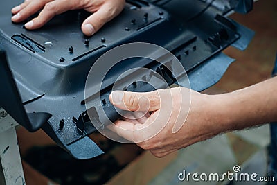Handling a molded plastic component with visible fastening points and structural elements Stock Photo