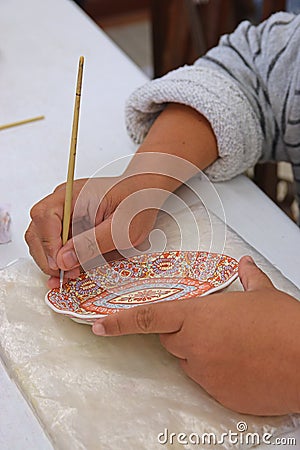 Handmade art of painting porcelain plate using brush Stock Photo