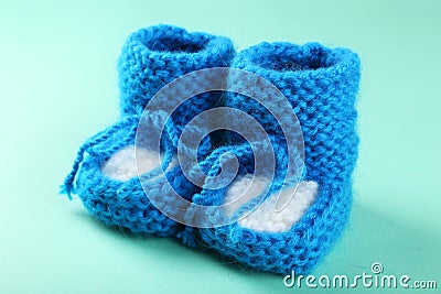 Handmade baby booties on the mint background Stock Photo