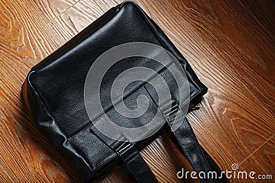 Handmade black leather bag on a wooden background, made of natural material Stock Photo