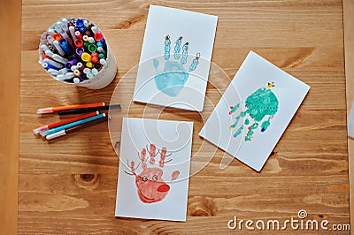 Handmade christmas handprints post cards and pencils on wooden table Stock Photo