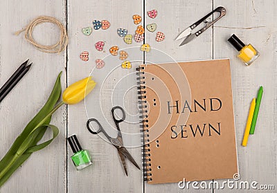 Handmade concept - sewing scissors, tulip, eco note pad with text Hand sewn, nail polish and buttons in the shape of hearts Stock Photo