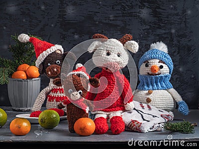 Handmade crocheted toys. A snowman in a blue hat and bulls in red caps Stock Photo