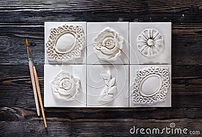 Handmade decor from a plaster relief stucco and a paintbrush for coloring Stock Photo