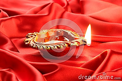 Handmade Diwali Clay Lamp on Red Satin Background Stock Photo