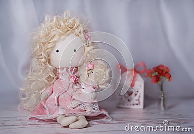 Handmade doll on a white wooden table with paper flowers and gift box Stock Photo