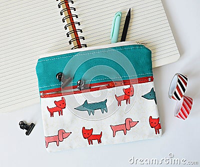 Double pocket pouch with dogs, clips, pencils, notebook and washi tape over white Stock Photo