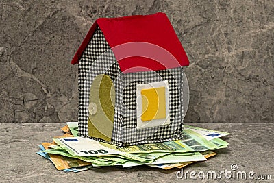 Handmade fabric house standing on the money pile Stock Photo