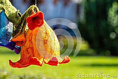 A handmade felt flower hangs in the garden on a sunny day Stock Photo