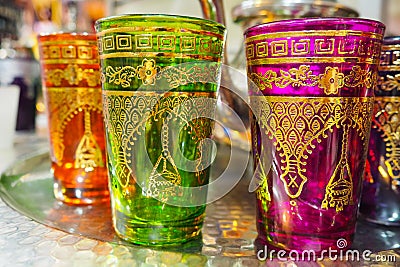 Handmade glass cups with bright colours and golden ornaments on display at street souvenir market in Morocco Stock Photo