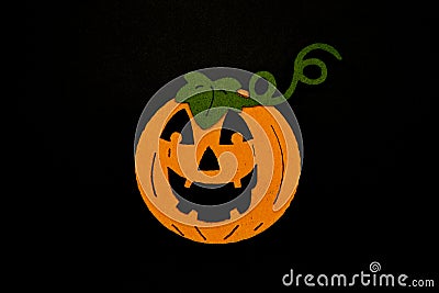 Handmade Halloween pumpkin with green leaves isolated on black background. Sponge pumpkin. Stock Photo