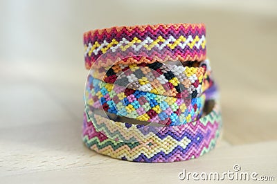 Handmade homemade colorful natural woven bracelets of friendship isolated on light blue background, pile of colorful handcrafts Stock Photo