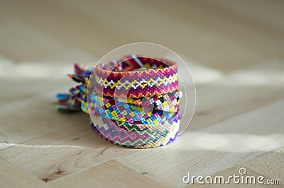 Handmade homemade colorful natural woven bracelets of friendship isolated on light blue background, pile of colorful handcrafts Stock Photo