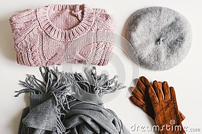 Handmade knitted sweater, gray scarf, beret hat, suede gloves on white background Stock Photo