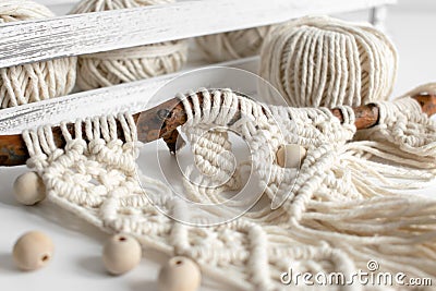 Handmade macrame braiding and cotton threads on rustic wooden stick. Boho image good for macrame and rustic handicrafts banners Stock Photo