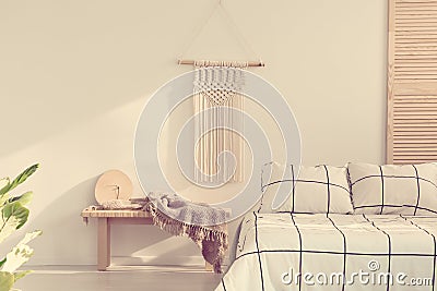 Handmade macrame on empty white wall of scandinavian bedroom interior Stock Photo