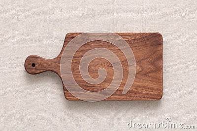 Handmade North American black walnut wooden chopping board on sackcloth. Walnut wood chopping board texture. Stock Photo