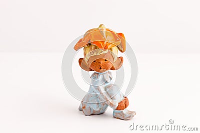 Handmade sitting elf figurine in white and orange Stock Photo