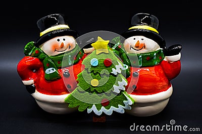 Handmade snowmen figurines isolated on black background. Christmas decoration. Stock Photo