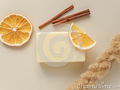 Handmade soap, dried plants, orange slices and cinnamon on beige background Stock Photo
