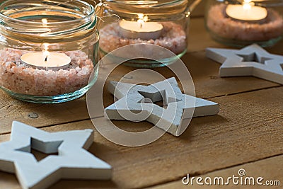 Handmade tea lights in jars with salt, wood decoration stars, close up, Christmas, New Year, advent Stock Photo