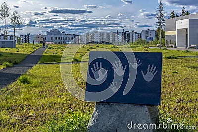 Family handprints on stone plate in alley in park residential urban complex Stock Photo