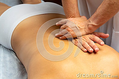 Hands applying pressure along spine on female patient Stock Photo