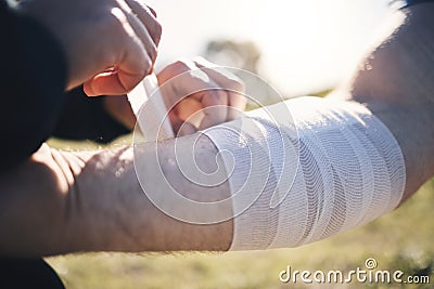 Hands, arm bandage and first aid after injury, workout or exercise accident outdoors. Medical emergency, help and Stock Photo