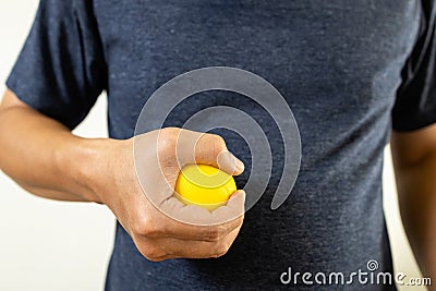 Hands of asian male holding a stress ball,man patient doing hand and wrist exercise,training with rubber ball,squeeze for muscle Stock Photo