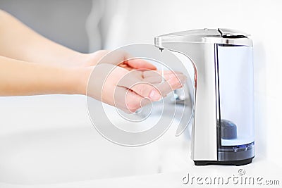 Hands and automatic soap dispenser Stock Photo