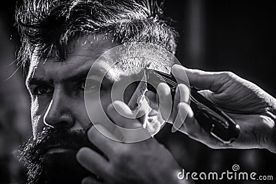 Hands of barber with hair clipper. Barber works with hair clipper. Hipster client getting haircut. Haircut concept. Man Stock Photo