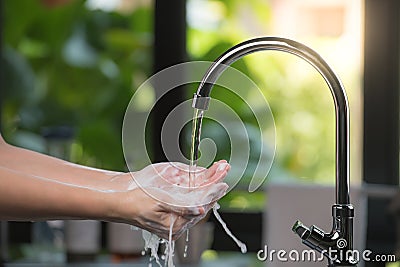 Hands being washed scrubbed and rinsed using disinfectant soap for hygiene and protection against COVID-19 and other dieseases Stock Photo