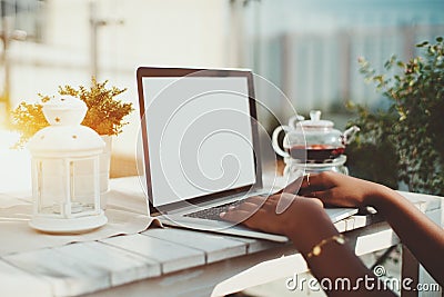 Hands of black girl keyboarding laptop with blank screen Stock Photo