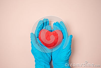 Hands in blue medical gloves holding heart shape. Thank you concept to doctors and medical workers during COVID-19 coronavirus Stock Photo