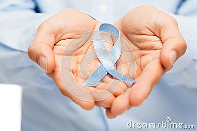 Hands with blue prostate cancer awareness ribbon Stock Photo