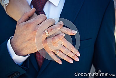 Hands of the bride and groom with gold rings, close-up. Embrace of newlyweds. Creating a loyal family Stock Photo