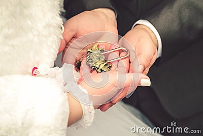 Hands of bride and groom with vintage lock Stock Photo