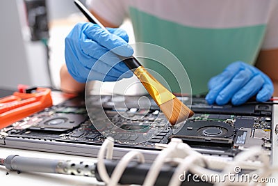 Hands brush the laptop parts from dust with a brush Stock Photo