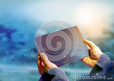 The hands of a business analyst holding a tablet looking for future business data, a foggy city background Stock Photo