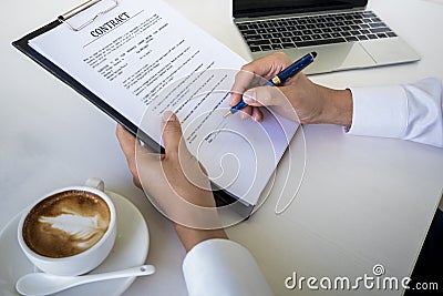 Hands of business man signing the contract document with pen on desk Stock Photo