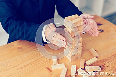Hands of businessman protect block wooden on table with risk concept Stock Photo