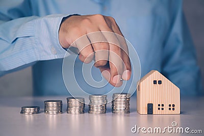 Hands of businessman and stack of coin with saving money for real estate and success. Stock Photo