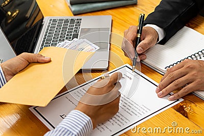 Hands of a businessman who bribed a female colleague who signed a contract in a male office offering a hundred dollar bills. Close Stock Photo