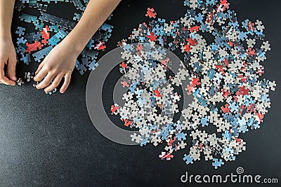 Hands of a child doing a puzzle Stock Photo