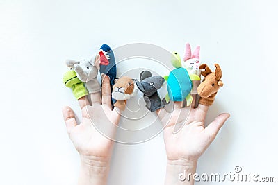 Hands of a child with finger puppets, toys, dolls close up on white background - playing puppet theatre and children entertainment Stock Photo