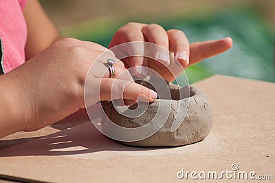 hands of child making clay pottery bowl in outdoor Stock Photo