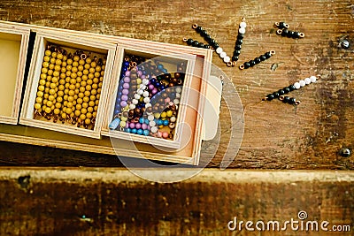 Hands of a child manipulating educational materials to learn to count in a Montessori classroom. Stock Photo