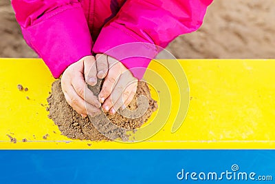 The hands of a child playing with sand. Stock Photo