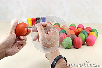 Hands of christian holding eggs and coloring with paint brush on table with copy space background. Stock Photo